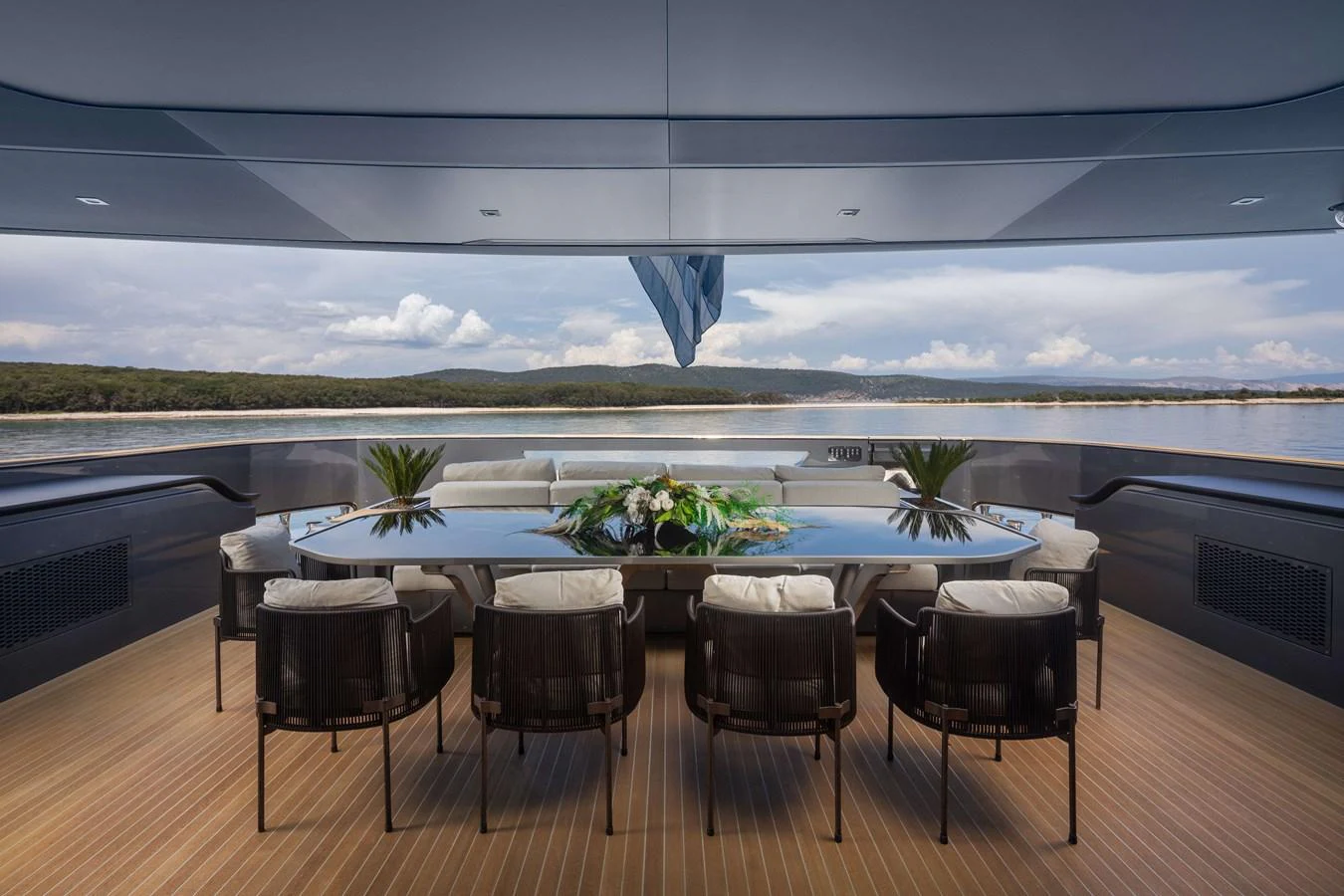 The aft deck features an elegant dining area with a stunning view of the surrounding waters. aboard PANAM Yacht for Sale