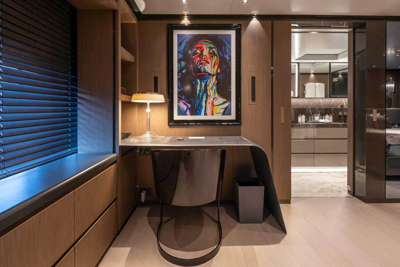 A stylish interior workspace featuring a modern desk, artistic wall decor, and ambient lighting. aboard PANAM Yacht for Sale