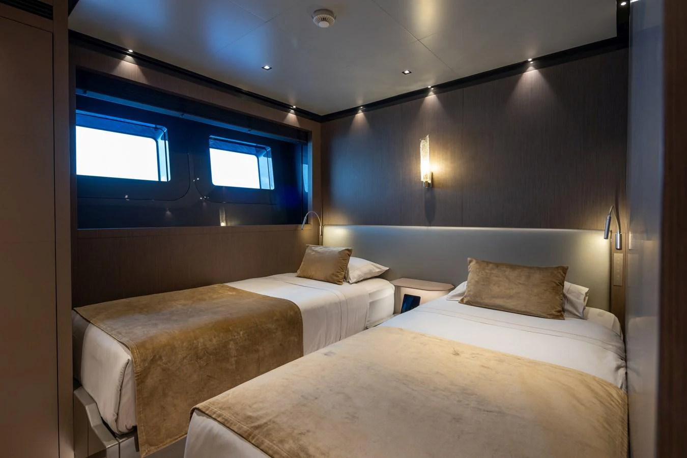 The guest stateroom features two single beds with elegant bedding and modern lighting. aboard PANAM Yacht for Sale