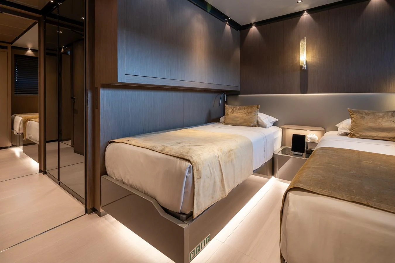 The guest stateroom features twin beds with elegant bedding and warm lighting. aboard PANAM Yacht for Sale