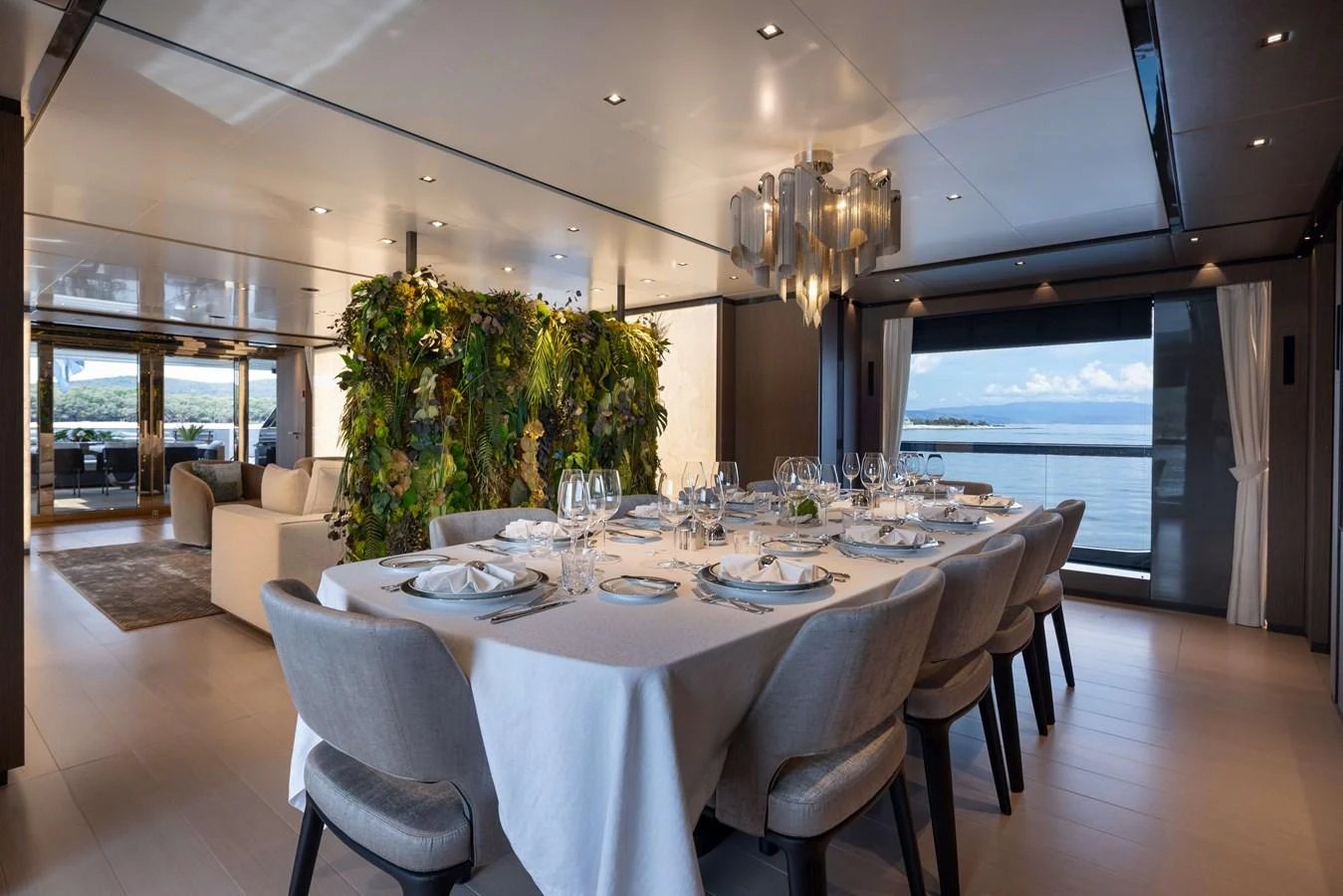 The yacht's dining area offers an elegant setting with a large table, plush seating, and panoramic views. aboard PANAM Yacht for Sale