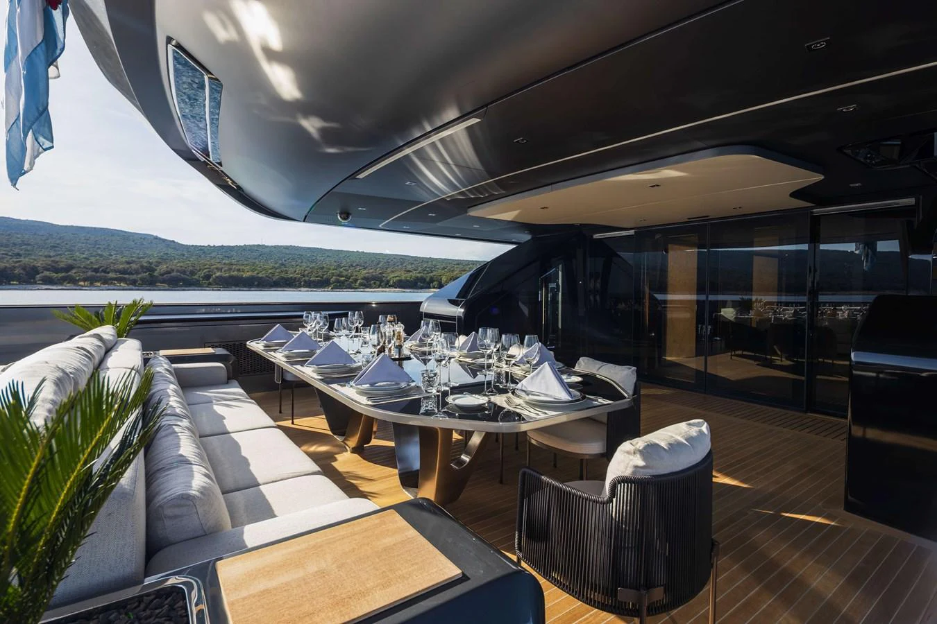 The aft deck features an elegant dining area with a large table and comfortable seating, perfect for alfresco meals. aboard PANAM Yacht for Sale