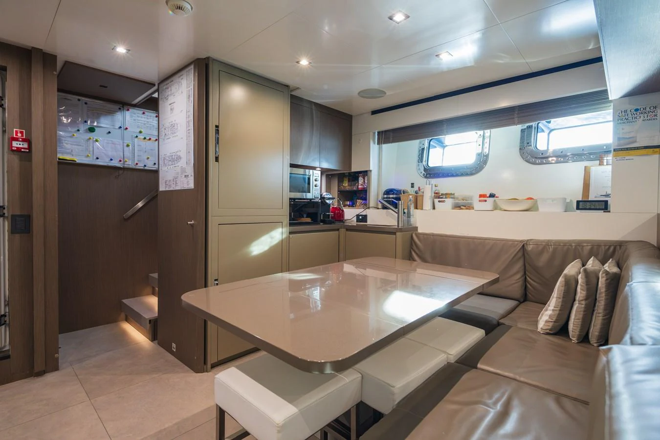 The yacht's dining area features a sleek table with comfortable seating and modern decor. aboard PANAM Yacht for Sale