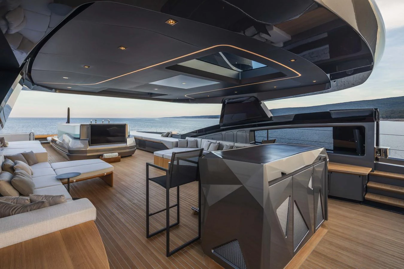 The aft deck features a spacious and modern lounging area with sleek furnishings and panoramic ocean views. aboard PANAM Yacht for Sale
