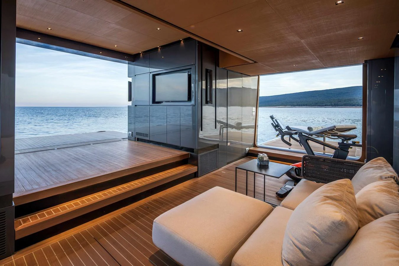 A luxurious lounge area opens up to a stunning sea view, featuring comfortable seating and modern decor. aboard PANAM Yacht for Sale