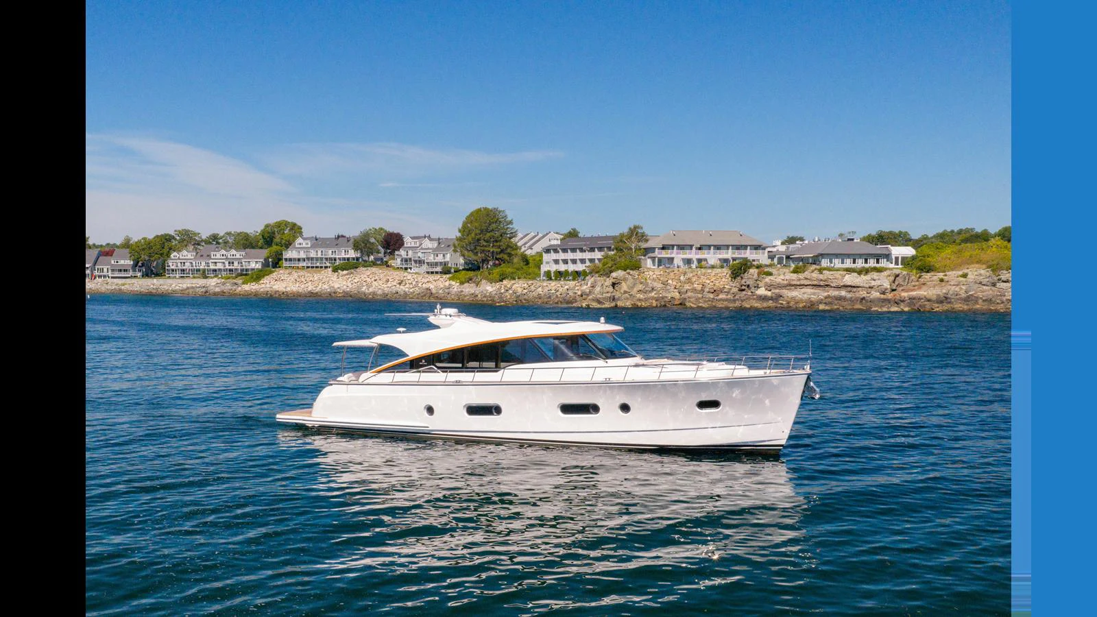 A sleek and modern yacht glides gracefully on calm waters with a picturesque shoreline in the background. aboard LYRICA Yacht for Sale