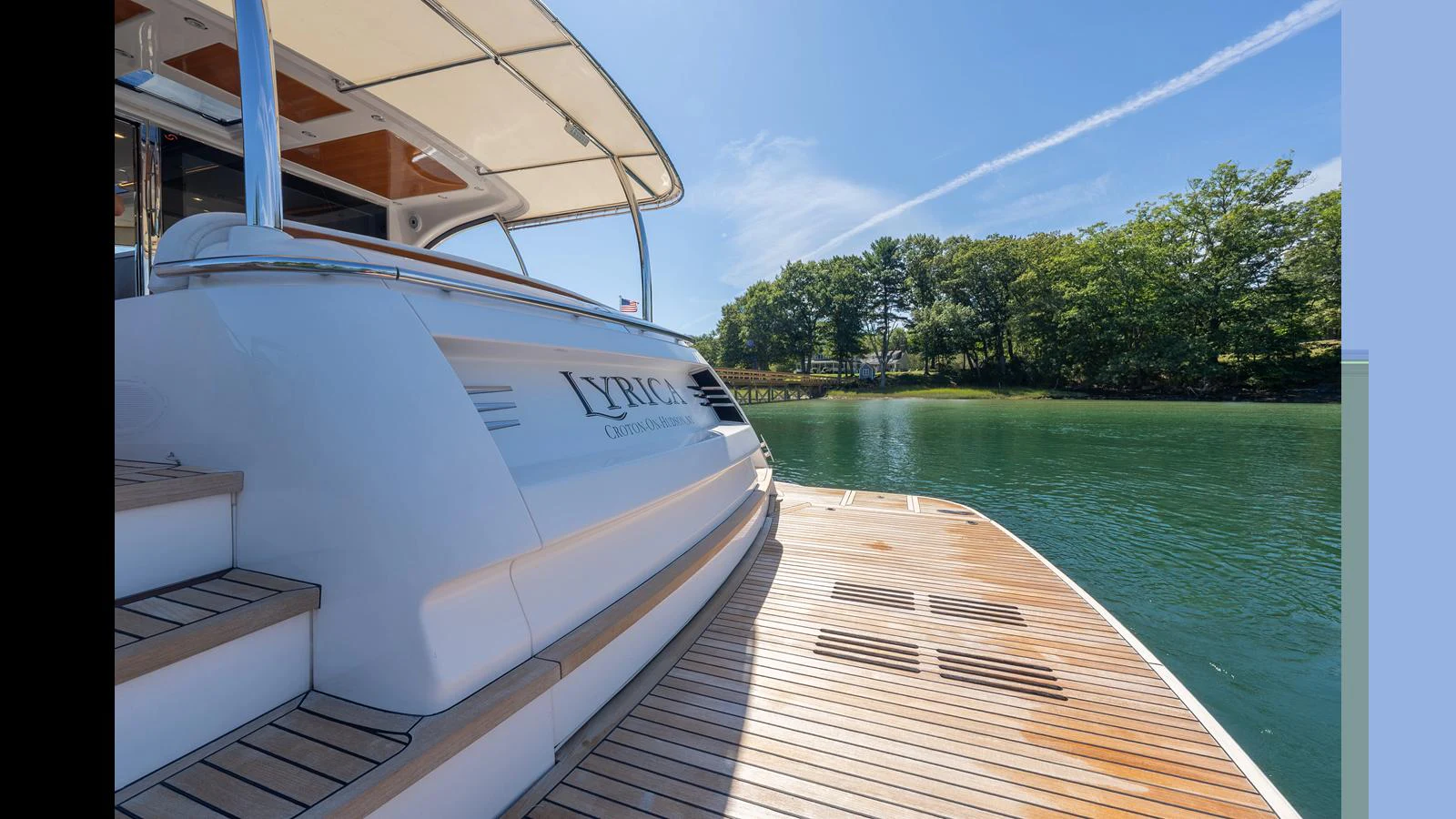 The aft deck of the yacht offers a serene view of the surrounding water and greenery. aboard LYRICA Yacht for Sale