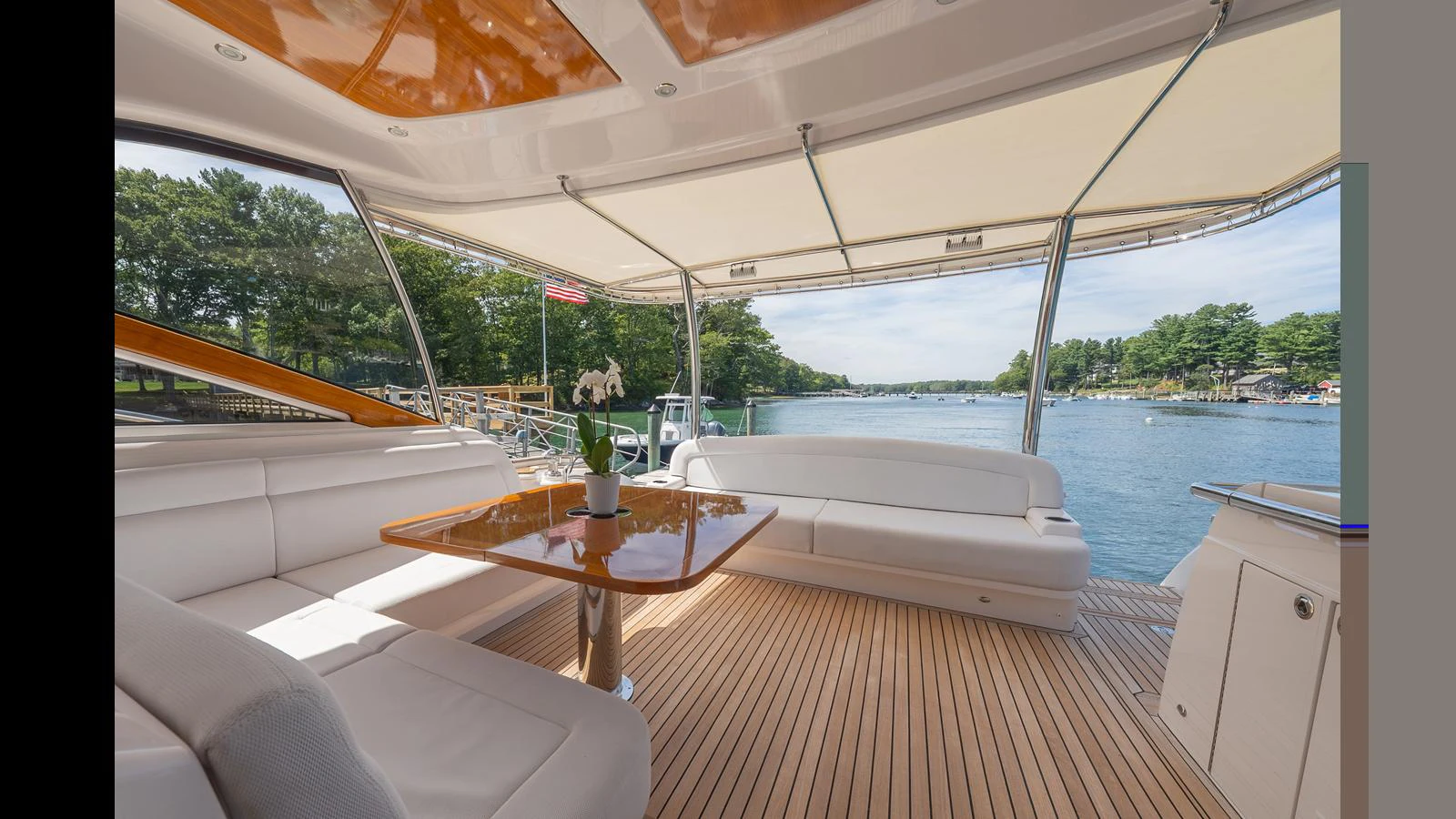 The aft deck features a spacious seating area with a polished wooden table, perfect for enjoying the scenic views. aboard LYRICA Yacht for Sale