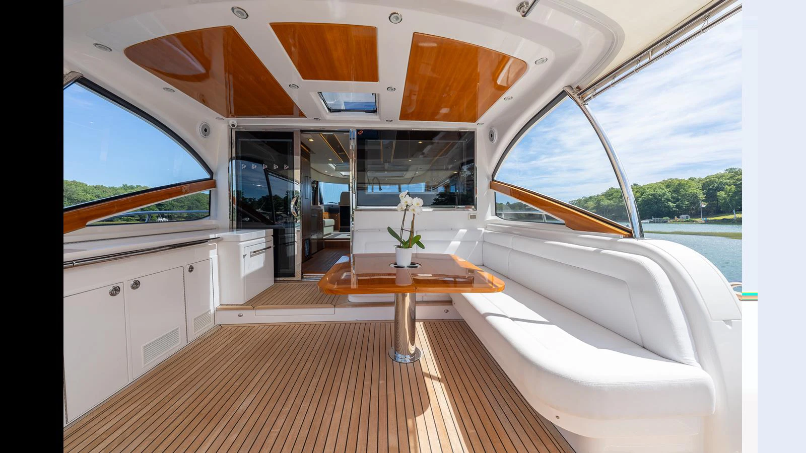 The aft deck features a spacious seating area with a wooden table and panoramic views. aboard LYRICA Yacht for Sale