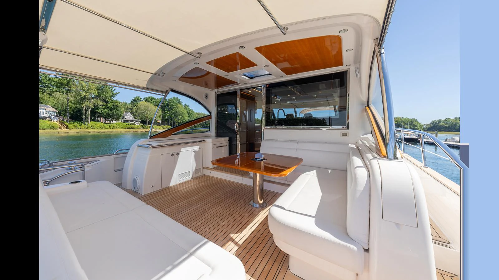 The aft deck features a spacious seating area with a wooden table, perfect for outdoor relaxation and dining. aboard LYRICA Yacht for Sale