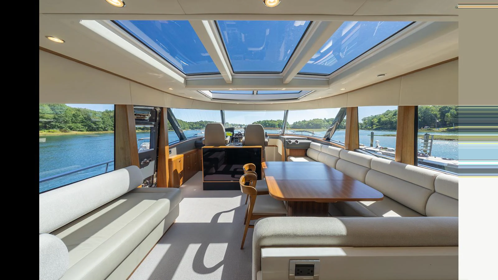 The yacht's salon features a spacious seating area with panoramic windows and a skylight, offering a bright and inviting atmosphere. aboard LYRICA Yacht for Sale