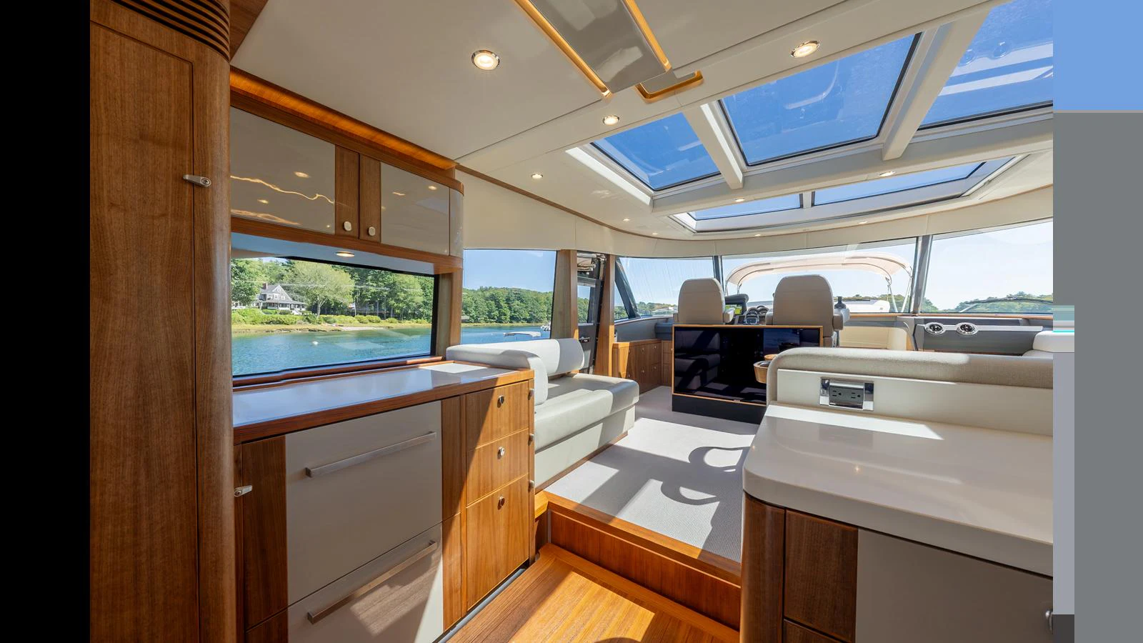 The salon features ample natural light with large windows and a skylight, complemented by elegant wood finishes. aboard LYRICA Yacht for Sale
