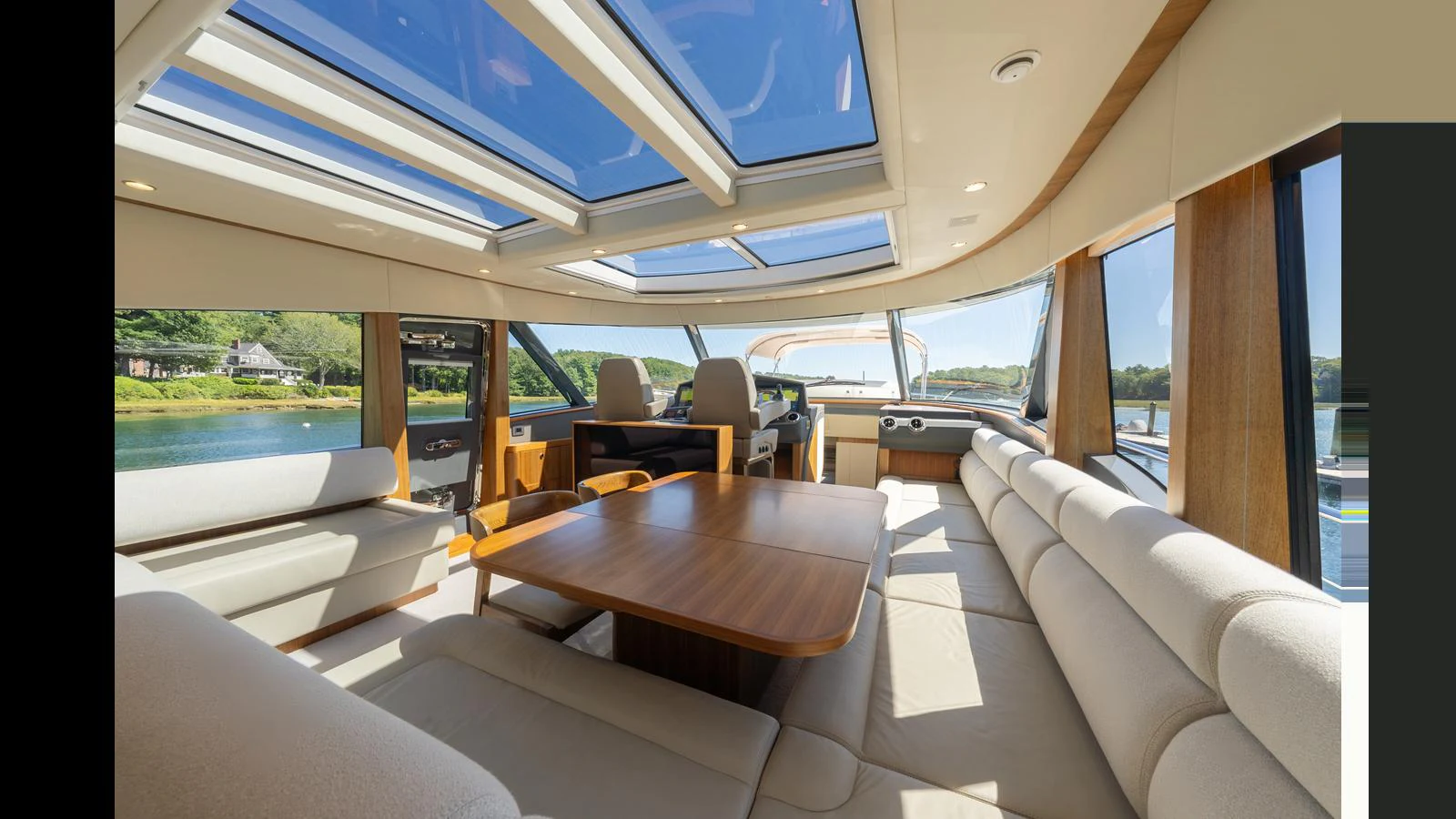 The yacht's salon features ample seating with panoramic windows and a skylight for natural light. aboard LYRICA Yacht for Sale
