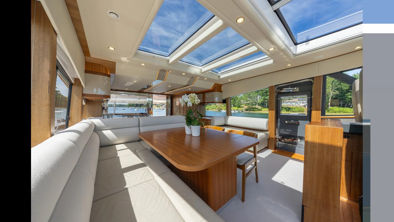 The salon features a spacious seating area with large windows and skylights, creating a bright and inviting atmosphere. aboard LYRICA Yacht for Sale