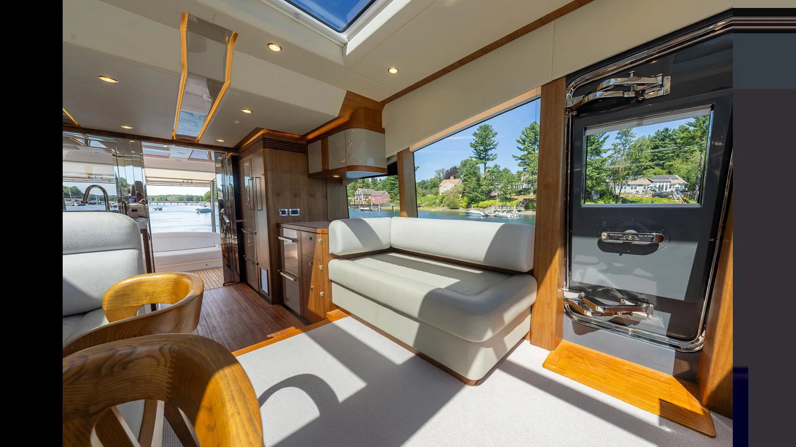 The yacht's interior features a bright and spacious seating area with large windows and modern furnishings. aboard LYRICA Yacht for Sale