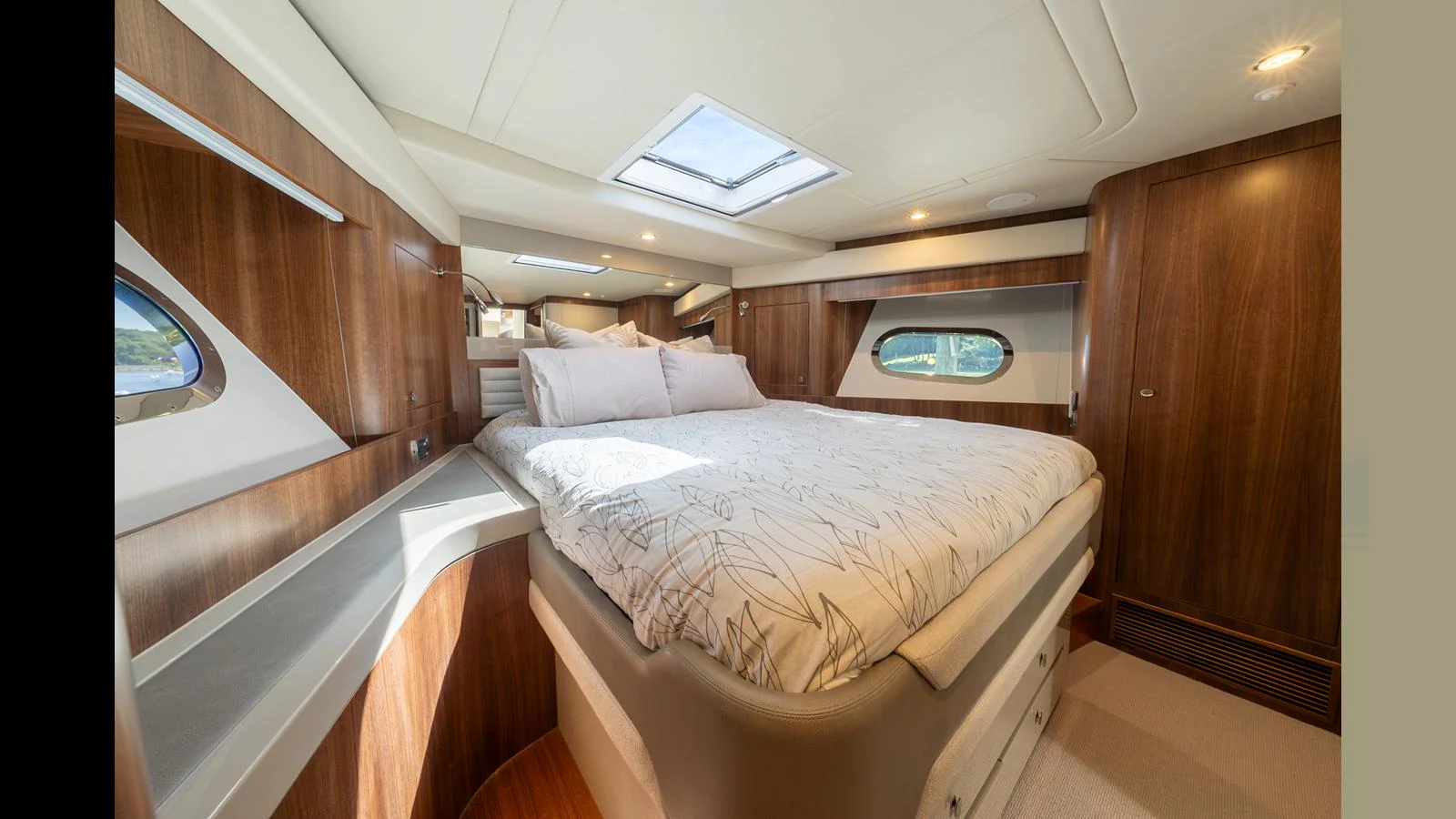 The master stateroom features a luxurious bed with ample natural light from the windows and skylight. aboard LYRICA Yacht for Sale