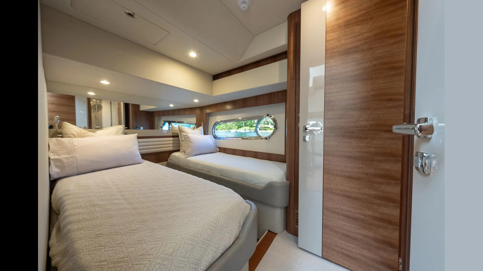 The guest stateroom features twin beds with elegant wood paneling and modern fixtures. aboard LYRICA Yacht for Sale