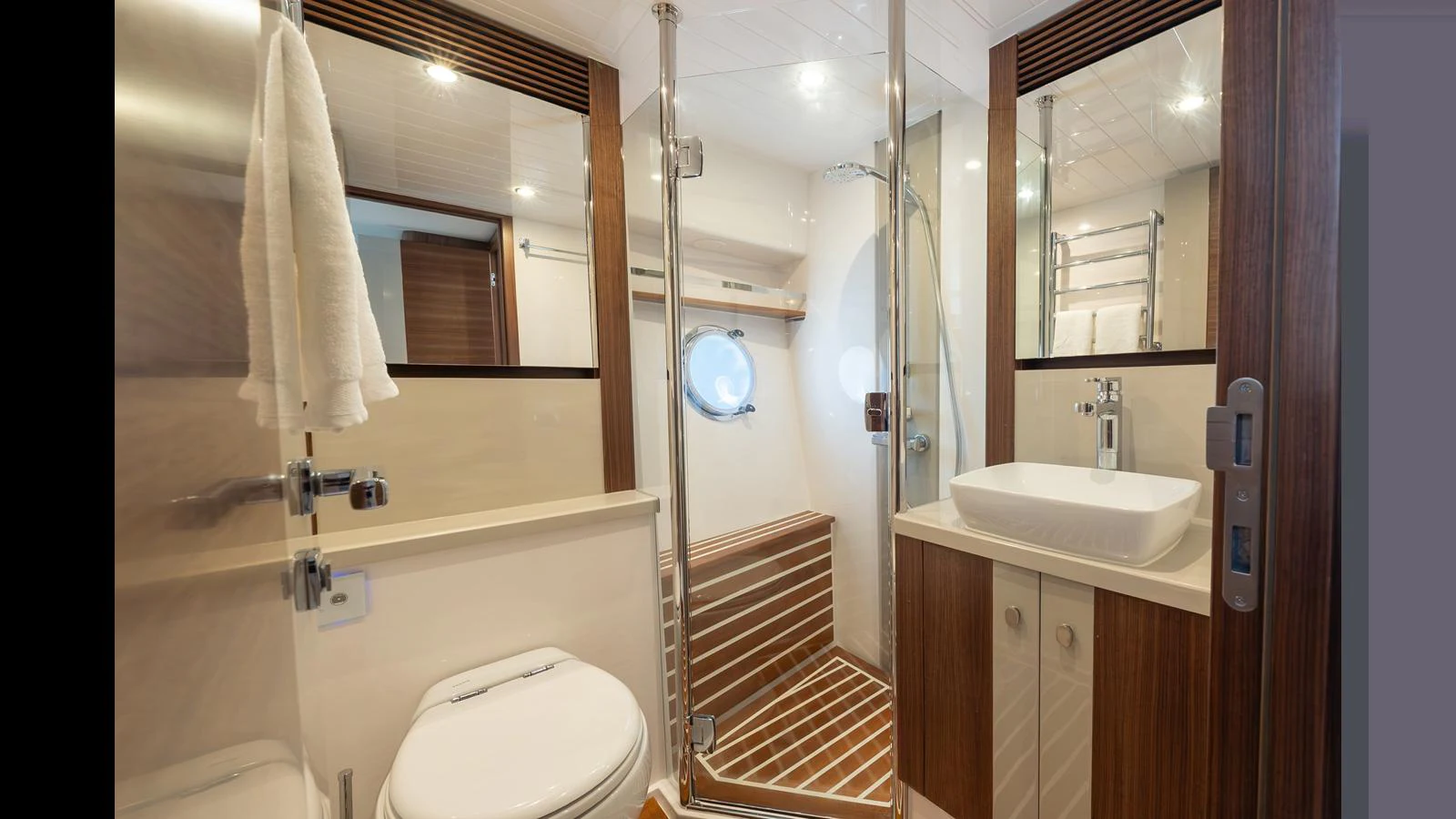 A modern yacht bathroom featuring a glass-enclosed shower, sleek sink, and wooden accents. aboard LYRICA Yacht for Sale