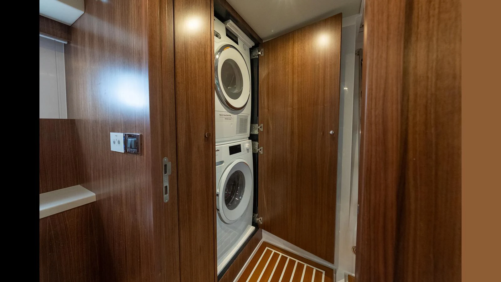 The yacht features a well-appointed laundry room with modern appliances and wooden cabinetry. aboard LYRICA Yacht for Sale