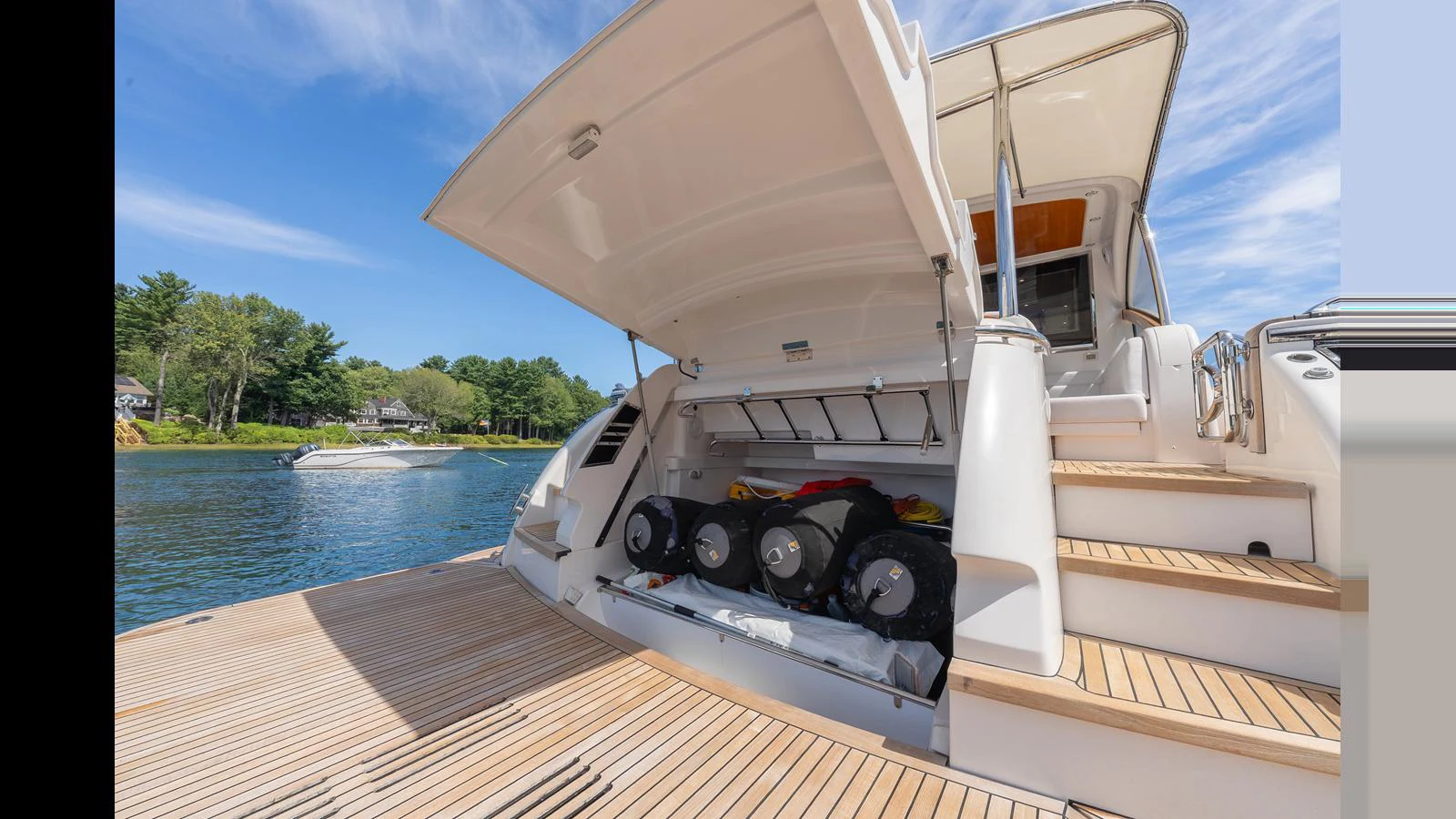The yacht features a spacious aft deck with an open storage compartment for water toys and equipment. aboard LYRICA Yacht for Sale