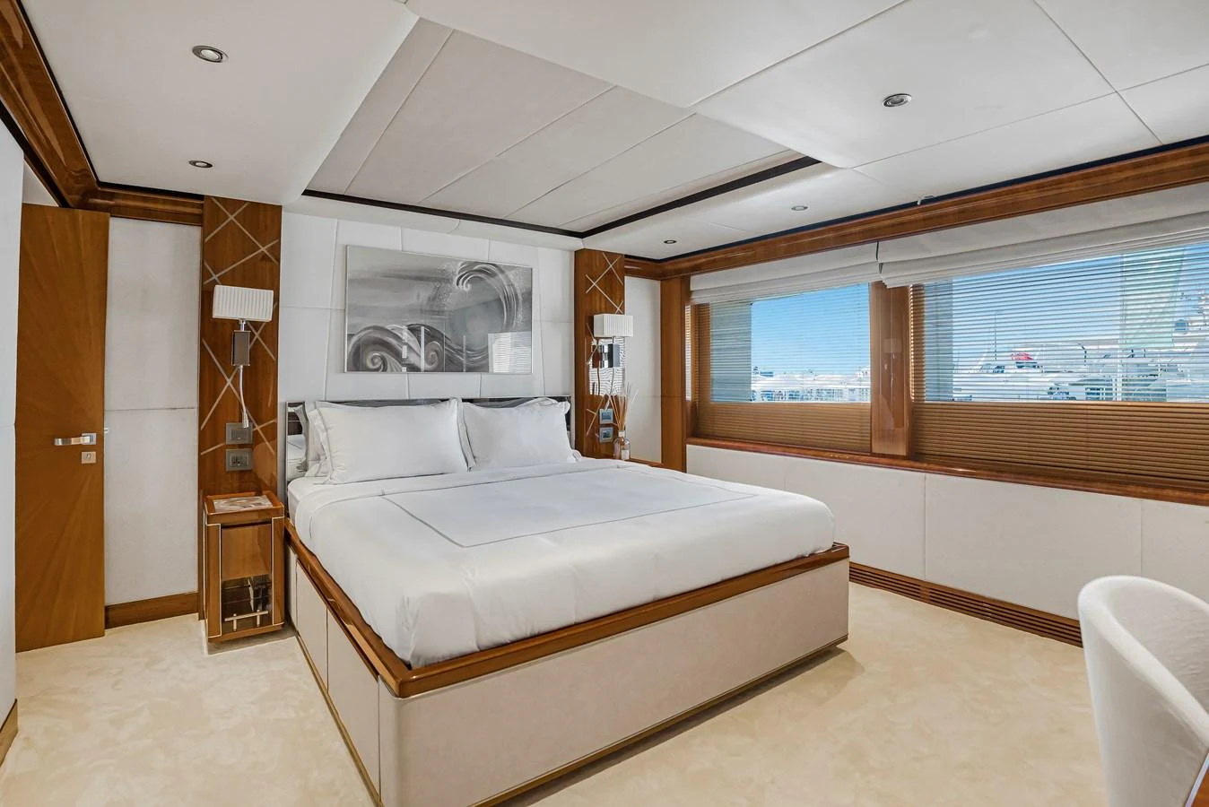 The master stateroom features a spacious bed with elegant decor and large windows offering natural light. aboard ATLANTIS Yacht for Sale