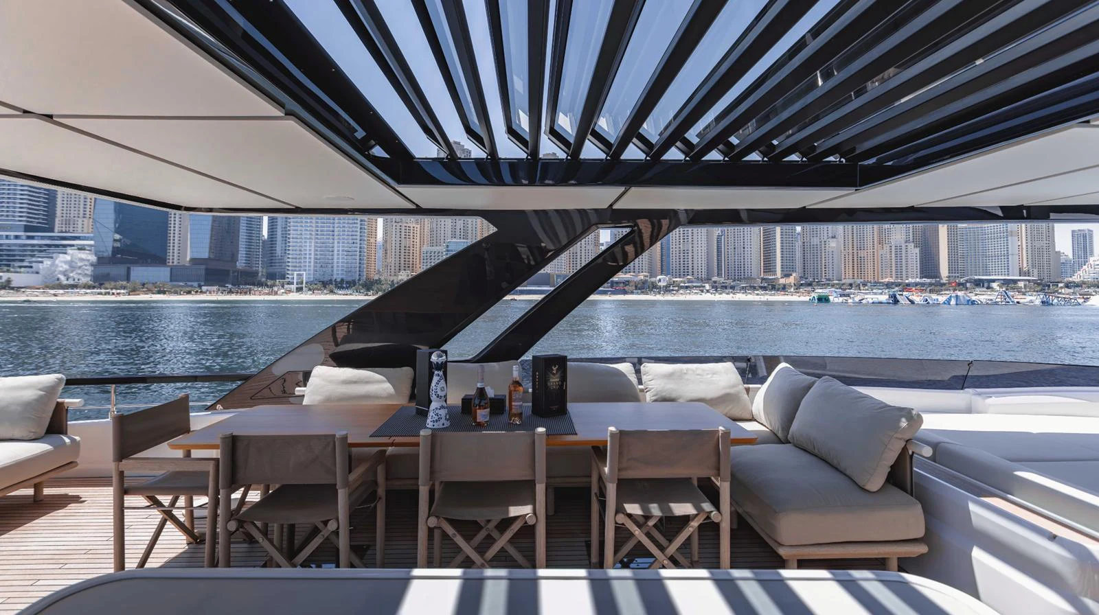 The aft deck features a spacious seating area with a dining table, perfect for enjoying meals with a view of the water. aboard AMANI Yacht for Sale