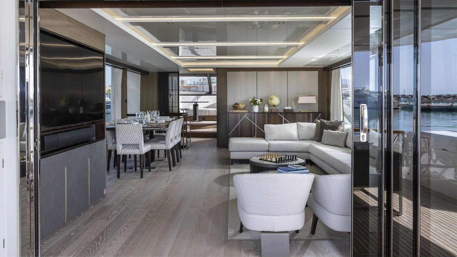The yacht's salon features a spacious and elegantly designed seating area with modern furnishings and a dining table. aboard W OF JERSEY Yacht for Sale