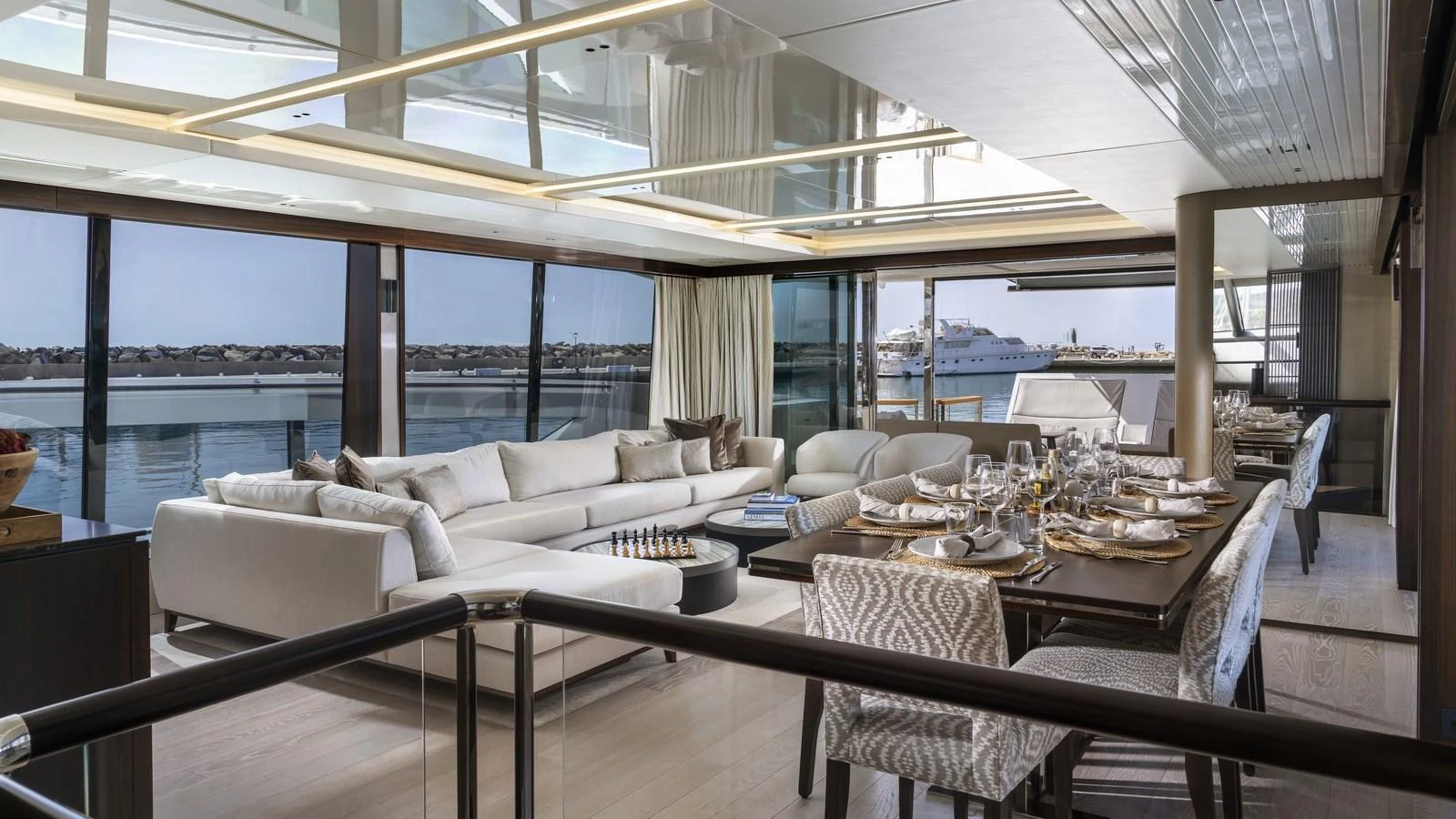 The salon offers a spacious and luxurious setting with ample seating and a dining area, all framed by panoramic windows. aboard W OF JERSEY Yacht for Sale