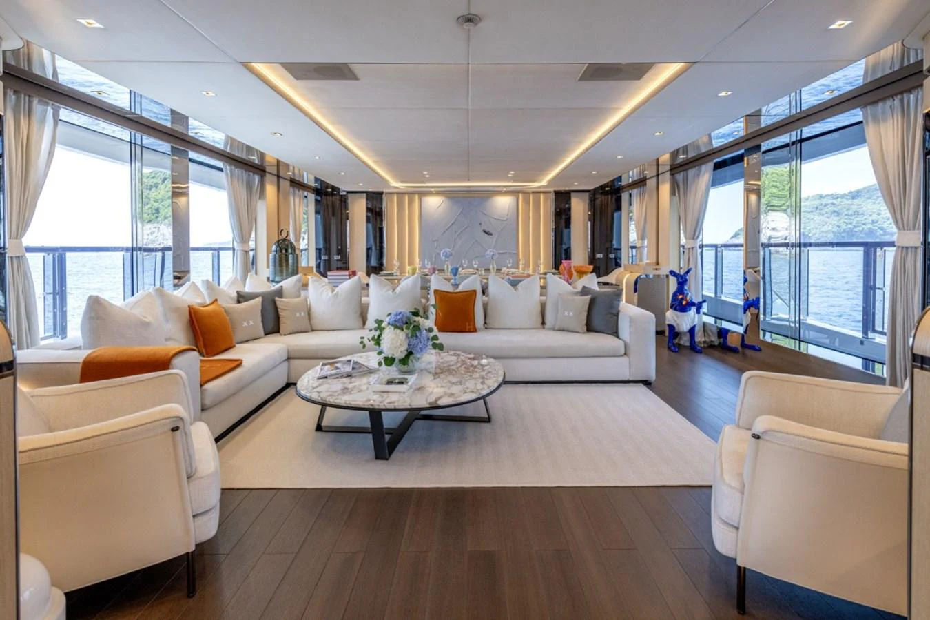 The spacious salon features elegant seating and panoramic views through large windows. aboard TOY Yacht for Sale