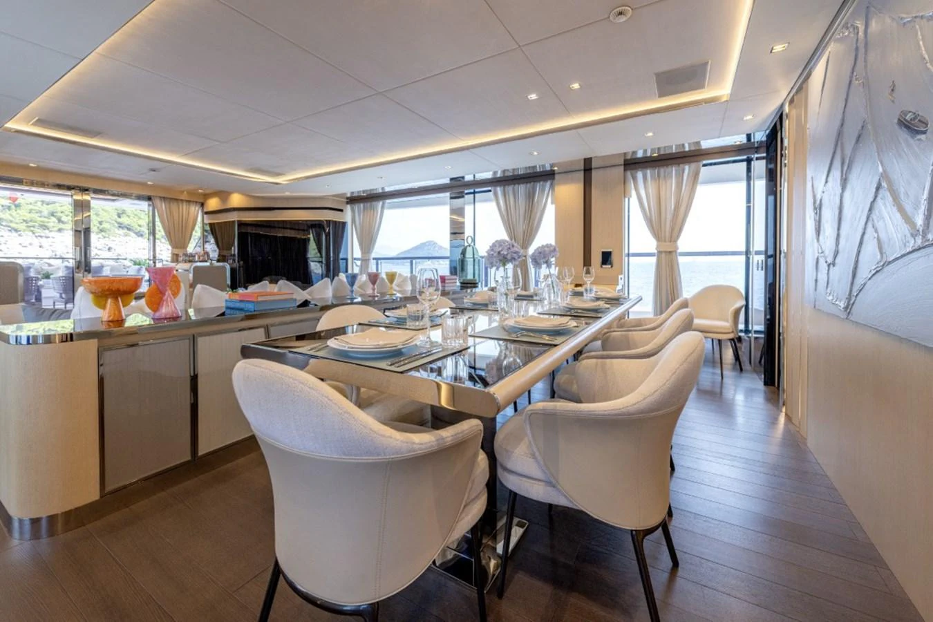 The yacht's dining area features elegant seating and a beautifully set table with panoramic views. aboard TOY Yacht for Sale