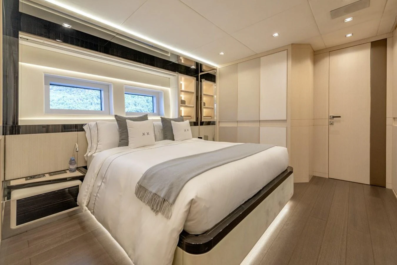 The stateroom features a luxurious bed with elegant bedding and ample natural light from the windows. aboard TOY Yacht for Sale