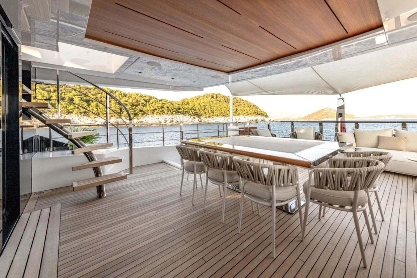 The aft deck features a spacious dining area with elegant seating and a stunning view of the surrounding waters. aboard TOY Yacht for Sale