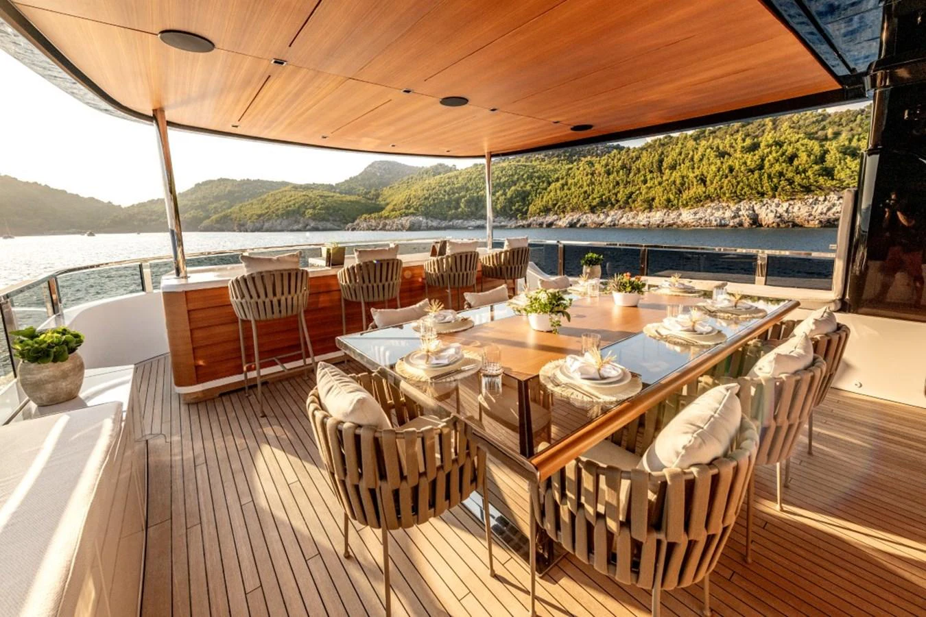 The aft deck features an elegant dining area with a stunning view of the surrounding landscape. aboard TOY Yacht for Sale