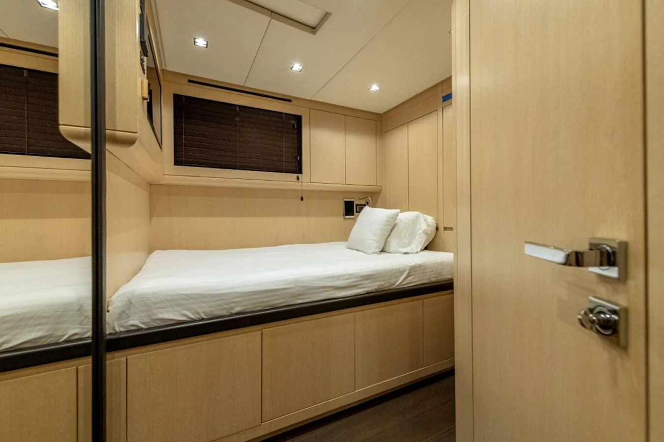 The guest stateroom features a comfortable bed with ample storage and modern lighting. aboard TOY Yacht for Sale