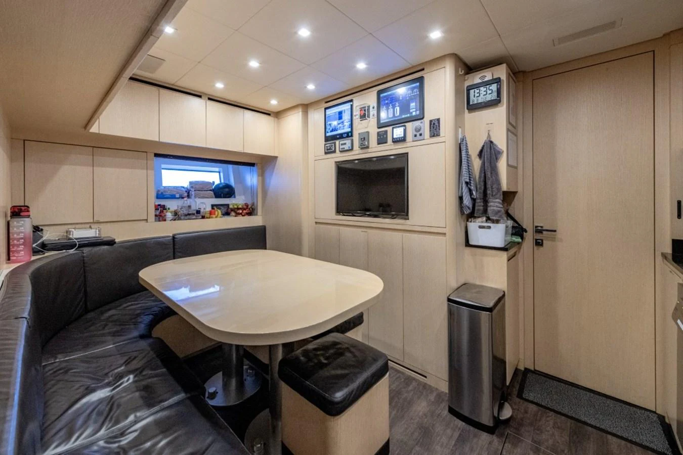 The galley features a cozy dining area with a built-in bench and modern appliances. aboard TOY Yacht for Sale