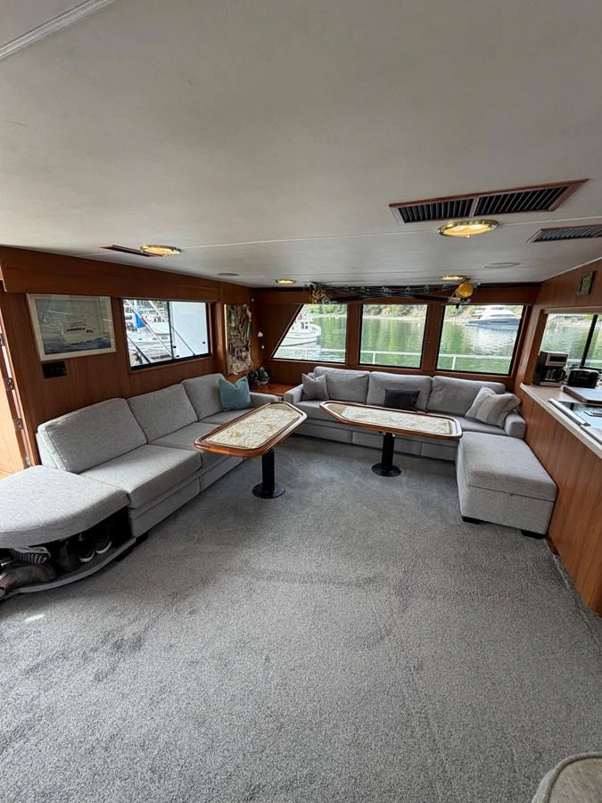 The salon features comfortable seating with large windows providing ample natural light and scenic views. aboard OCEAN PACIFIC Yacht for Sale