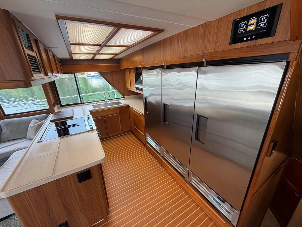 The galley features modern stainless steel appliances and ample wooden cabinetry, creating a warm and functional space. aboard OCEAN PACIFIC Yacht for Sale