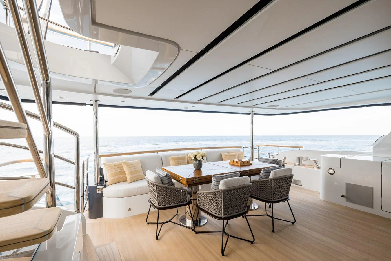 The aft deck features a stylish dining area with comfortable seating and a stunning ocean view. aboard ADVA Yacht for Sale