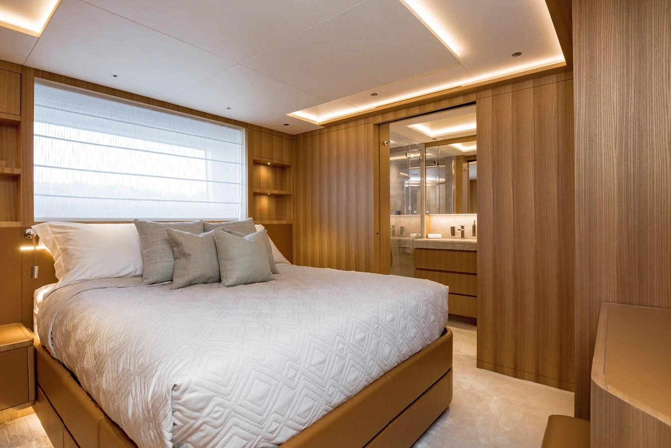 The master stateroom features a luxurious bed with ample natural light and elegant wood paneling. aboard ADVA Yacht for Sale