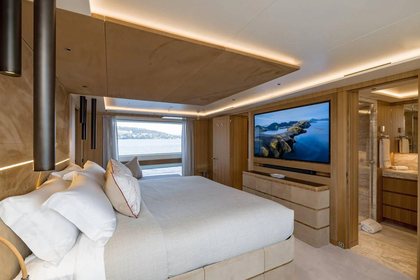 The master stateroom features a luxurious bed, modern decor, and a large window with a scenic view. aboard ADVA Yacht for Sale