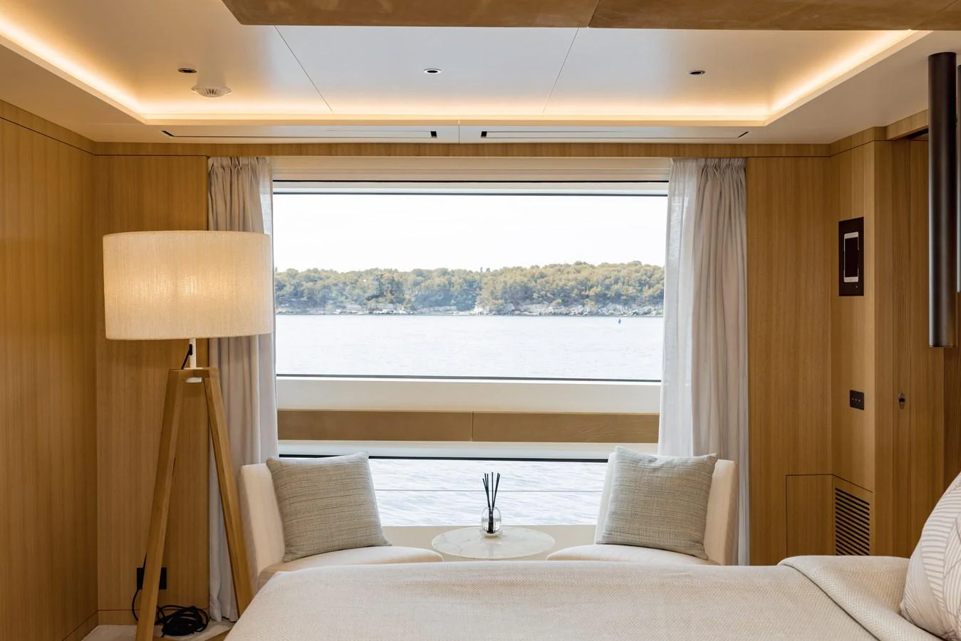 A serene stateroom with a large window offering a picturesque view of the water. aboard ADVA Yacht for Sale