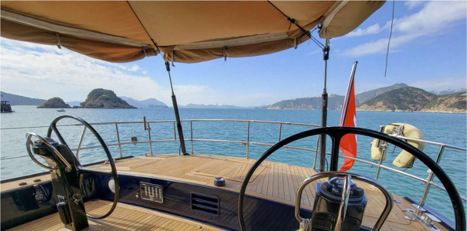 The aft deck offers a serene view of the surrounding waters and distant islands, perfect for relaxation. aboard NAUTOR SWAN 90 Yacht for Sale