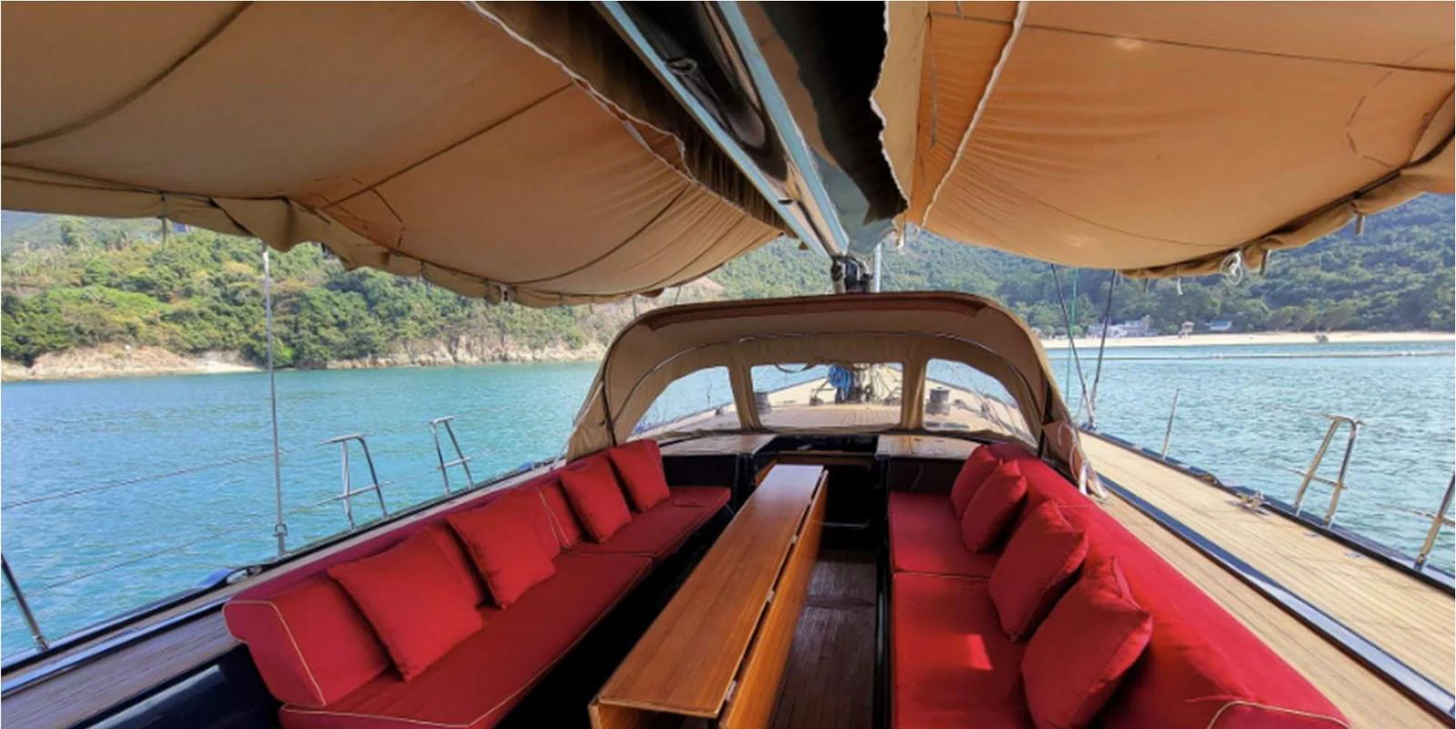 The yacht features a spacious deck seating area with comfortable red cushions and a central wooden table, perfect for outdoor relaxation. aboard NAUTOR SWAN 90 Yacht for Sale