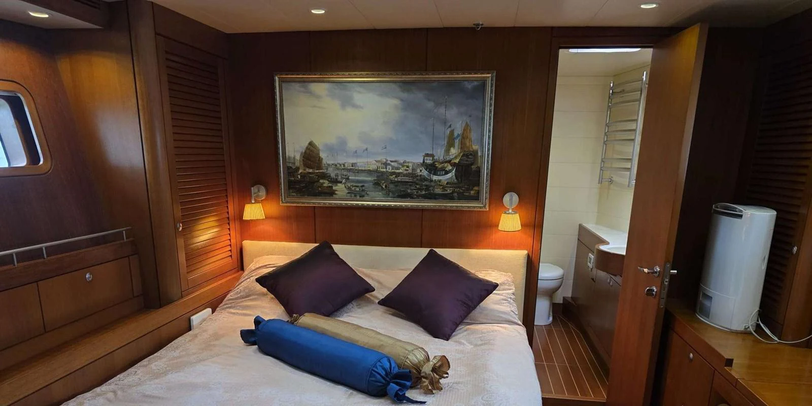 A cozy stateroom with a large bed and an en-suite bathroom, featuring warm wooden finishes and elegant decor. aboard NAUTOR SWAN 90 Yacht for Sale