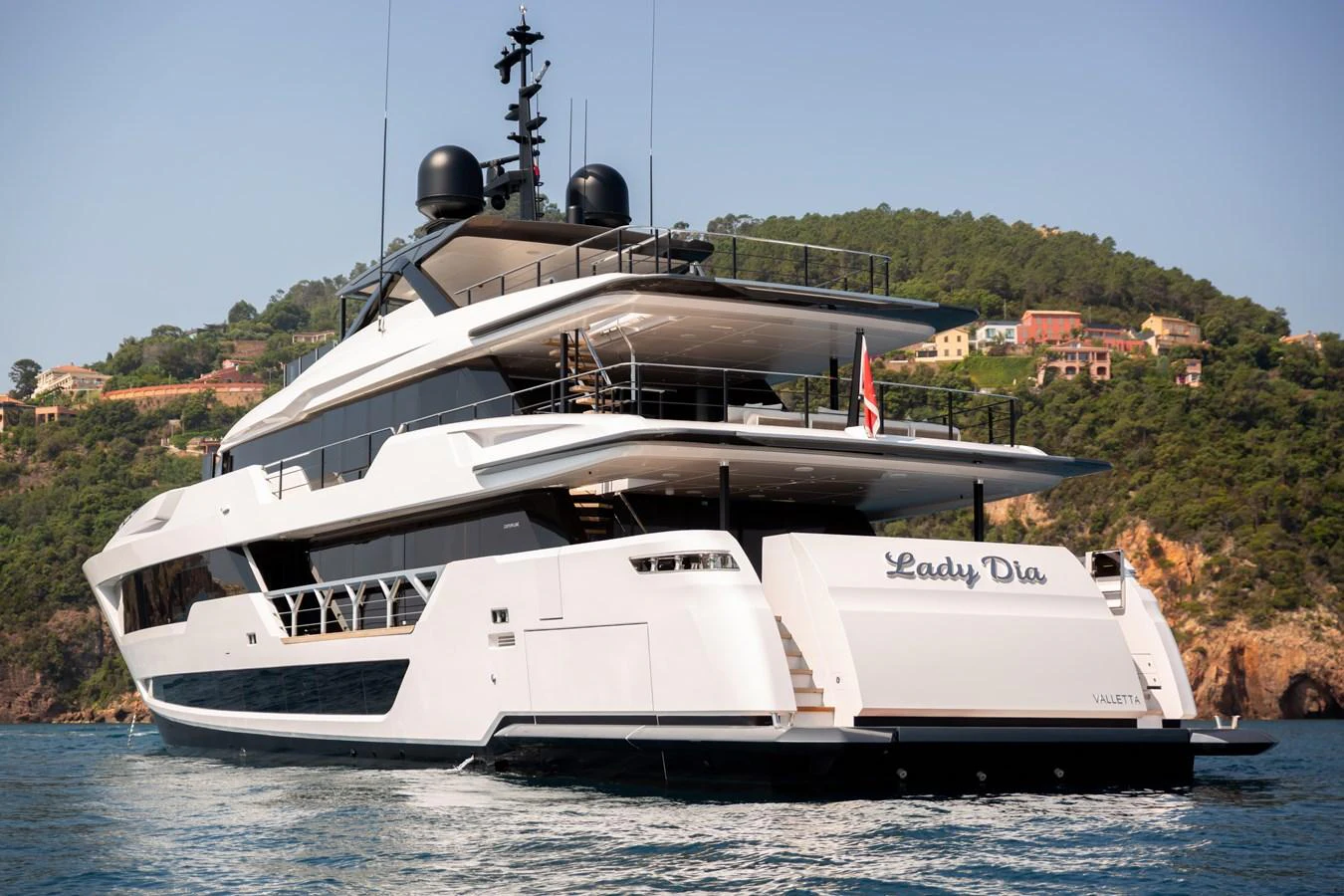 A luxurious yacht is anchored in a scenic coastal area, showcasing its sleek design and spacious decks. aboard LADY DIA Yacht for Sale