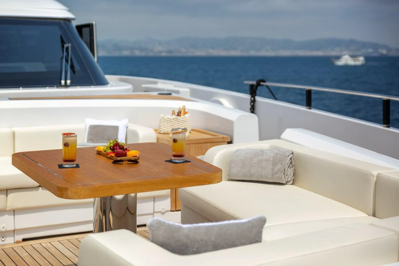 The aft deck features a comfortable seating area with a wooden table, perfect for enjoying refreshments while taking in the ocean view. aboard LADY DIA Yacht for Sale