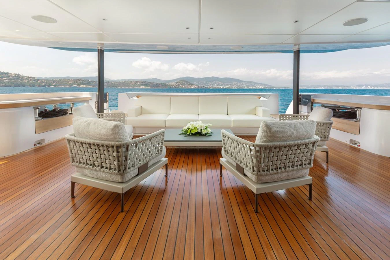 The aft deck features a spacious seating area with comfortable chairs and a central table, offering stunning views of the surrounding waters. aboard LADY DIA Yacht for Sale