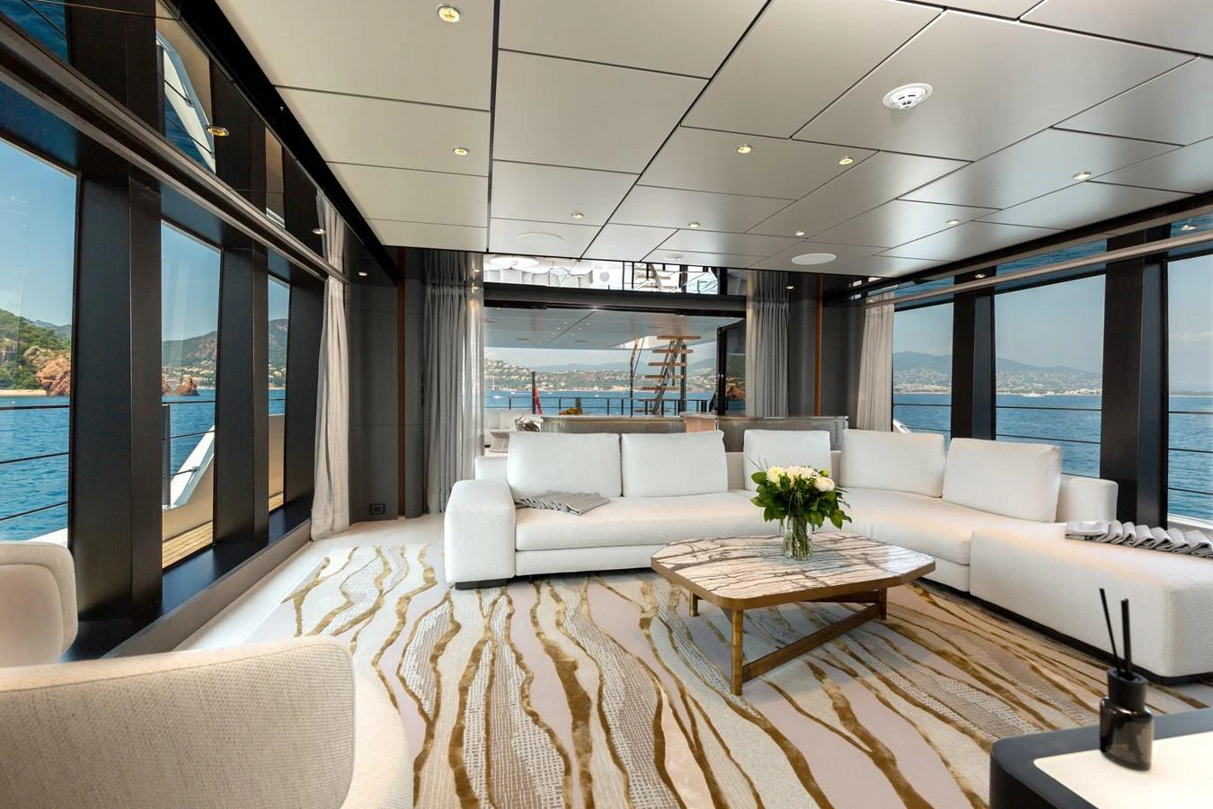 The spacious salon features luxurious seating and panoramic windows offering stunning sea views. aboard LADY DIA Yacht for Sale