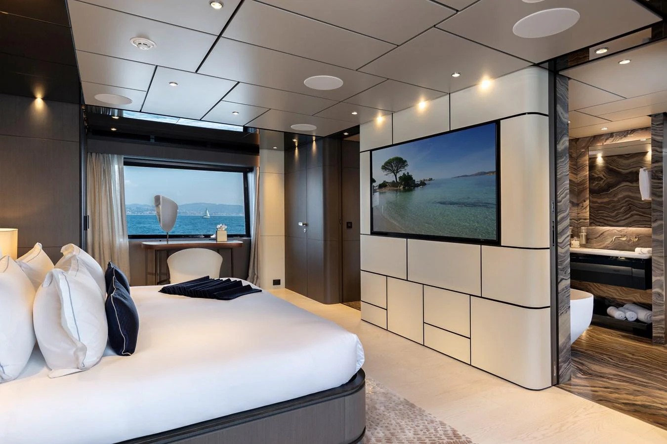 The master stateroom features a luxurious bed, a large window with an ocean view, and a spacious en-suite bathroom. aboard LADY DIA Yacht for Sale
