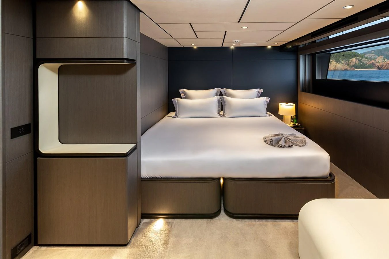 The stateroom features a luxurious bed with modern furnishings and a scenic view through the window. aboard LADY DIA Yacht for Sale